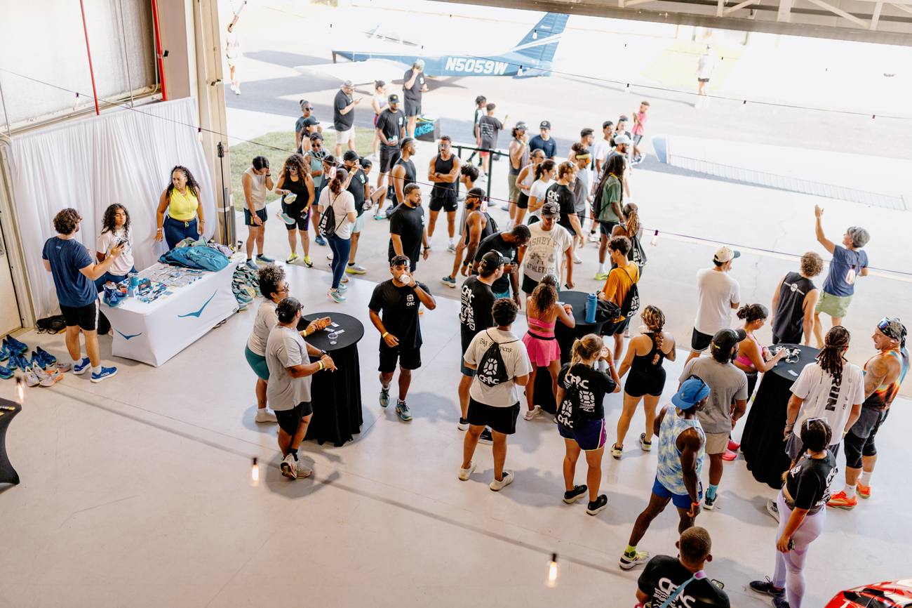 Crowd gathered inside an aircraft hangar at a Chosen Few Run Club event